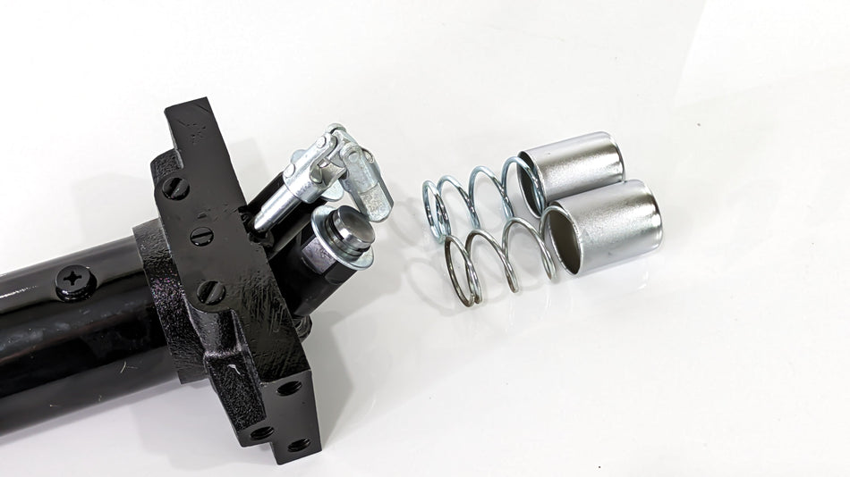 Replacement pump unit for a black rugged floor jack, consisting of metal springs, bolts, and other components.